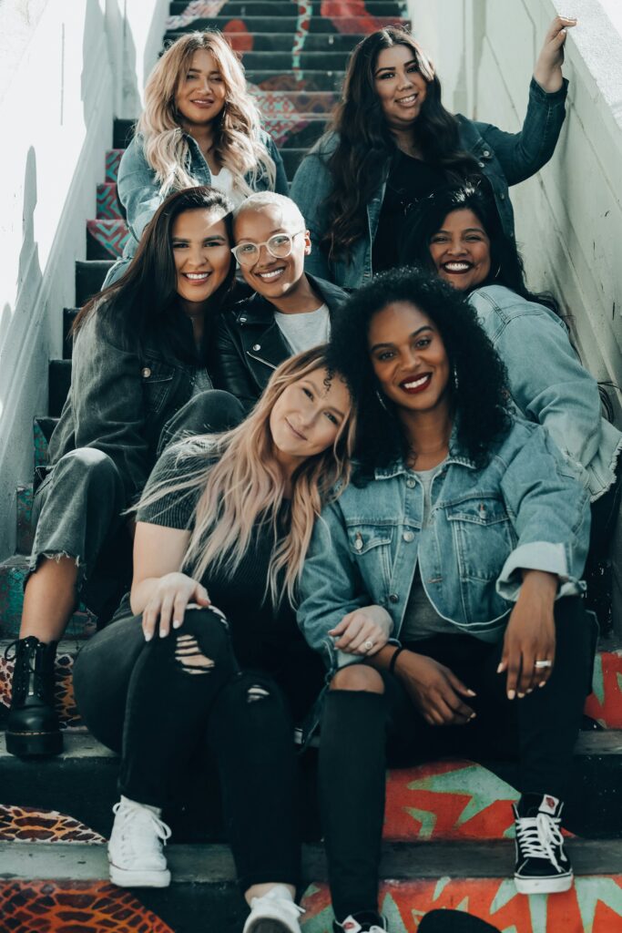 A group of women smiling together on a staircase